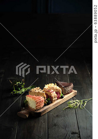 Different pieces of cakes on a wooden board . catering menu Different pieces of cakes on a wooden board . catering menu 63889052