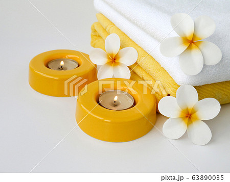 Towels, two candles and three frangipani flowers Towels, two candles and three frangipani flowers 63890035