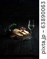 Glass of cold white wine with cheese snack on a wooden. catering menu 63890063