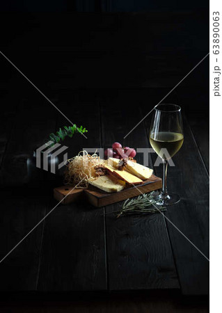 Glass of cold white wine with cheese snack on a wooden. catering menu Glass of cold white wine with cheese snack on a wooden. catering menu 63890063