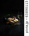 Glass of cold white wine with cheese snack on a wooden. catering menu 63890113