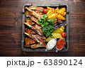 Barbecue on the bones with vegetables and potatoes . catering menu 63890124