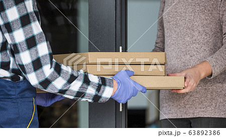 The courier brings boxes of the face to the order door 63892386