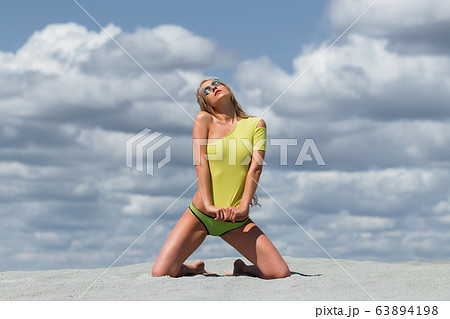 Seductive woman in stylish swimsuit kneeling in 63894198