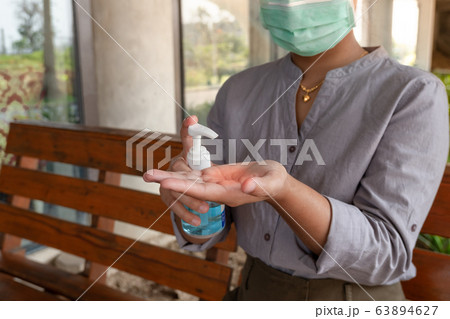 Young women hand holding a hand sanitizer to prevent virus infection Covid-19 protection device Young women hand holding a hand sanitizer to prevent virus infection Covid-19 protection device 63894627