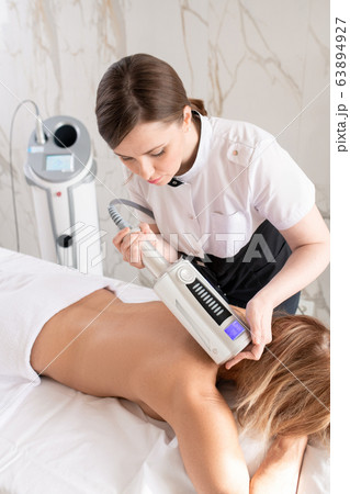 Massaging back with body massager 63894927
