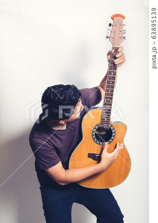 man playing guitar acoustic wearing t-shirt 63895139