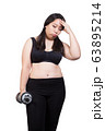 fat woman over training headache feeling sick exercise weight loss concept hand holding dumbbell 63895214