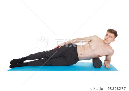 Handsome man shows exercises using a foam roller Handsome man shows exercises using a foam roller 63898277