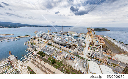 Aerial view of sea dry dock in La Ciotat city, France, the cargo crane, boats on repair, a luxury sail yacht and motor yacht, mountain is on background, shipyard 63900022