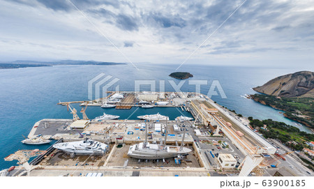Aerial view of sea dry dock in La Ciotat city, France, the cargo crane, boats on repair, a luxury sail yacht and motor yacht, mountain is on background, shipyard 63900185