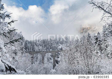 The Landwasser Viaduct with Railway without famous train at winter, landmark of Switzerland, snowing, river and mountains 63900385