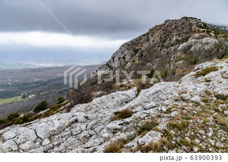 The mountain over grotto of Mary Magdalene at cloudy weather, clouds over a valley, a dry grass The mountain over grotto of Mary Magdalene at cloudy weather, clouds over a valley, a dry grass 63900393