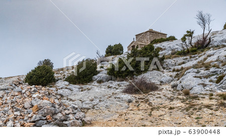 The chapel Saint-Pilon is on the mountain in cloudy weather, clouds over a valley, a dry grass, mountain over grotto of Mary Magdalene 63900448