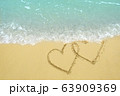 Two hearts drawn on the sand beach representing 63909369