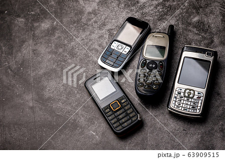 Many obsoleted cellphones on a grunge background. Many obsoleted cellphones on a grunge background. 63909515