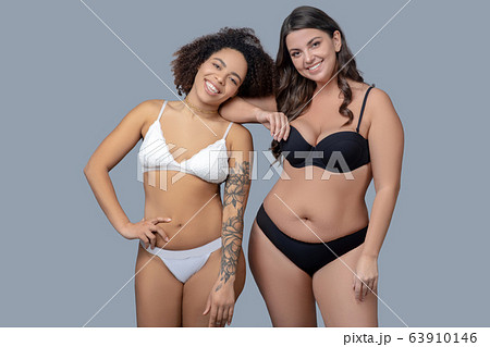 Two women in a good mood standing in underwear. Two women in a good mood standing in underwear. 63910146