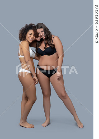 Two young girlfriends posing in underwear barefoot. Two young girlfriends posing in underwear barefoot. 63910173