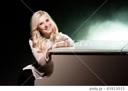 Portrait of a beautiful actress near a white piano. Portrait of a beautiful actress near a white piano. 63913015