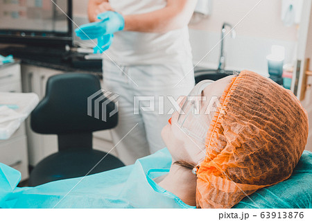 A cute girl is sitting in a dentist chair and 63913876