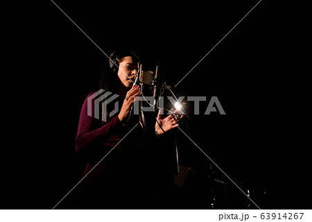 Portrait of woman recording a song in a professional studio Portrait of woman recording a song in a professional studio 63914267