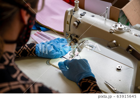 Sewing a protective face mask against Coronavirus 63915645