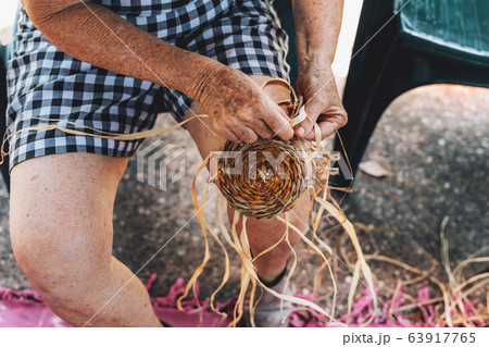 Old female weaving basket on the craft workshop. Hands holding the craftwork, close up shot Old female weaving basket on the craft workshop. Hands holding the craftwork, close up shot 63917765