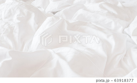 White bed sheet blanket, wrinkled duvet, crumpled comforter cloth used in hotel, resort or home interior for bedding background and sleep comfort White bed sheet blanket, wrinkled duvet, crumpled comforter cloth used in hotel, resort or home interior for bedding background and sleep comfort 63918377