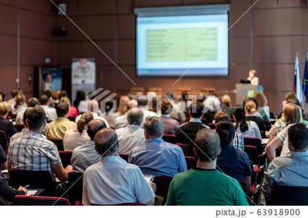 Woman giving presentation in lecture hall at university. 63918900