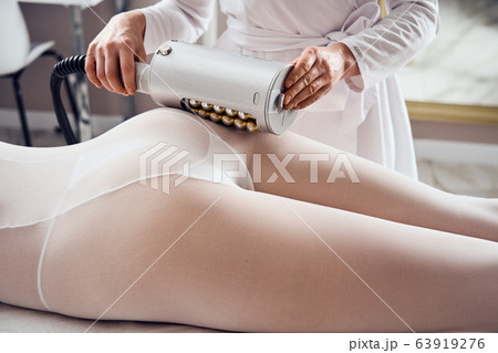 Masseur makes apparatus anti-cellulite massage in the cosmetology clinic Masseur makes apparatus anti-cellulite massage in the cosmetology clinic 63919276