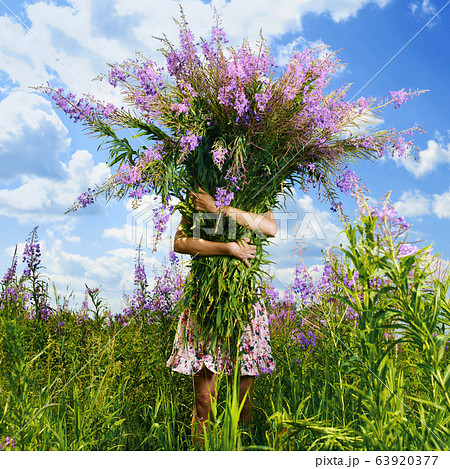 Young beautiful girl picks flowers in the field. 63920377