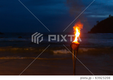 Burning torch on the sandy beach of the ocean Burning torch on the sandy beach of the ocean 63923208