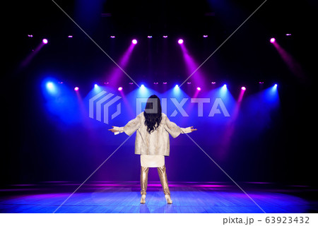 Actress on the stage in colorful bright beams of light. 63923432