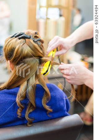 professional hairdresser using curling iron hair professional hairdresser using curling iron hair 63924494