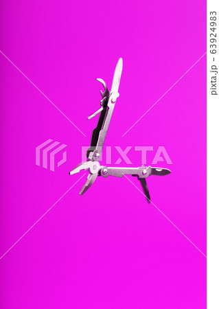 Multitool is a multi-functional tool on a pink 63924983