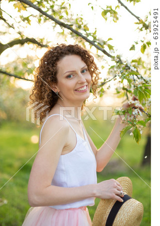 Young attractive woman with curly hair walking in 63925491