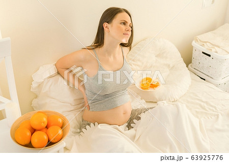 Portrait of young beautiful pregnant woman with oranges. Healthy food, natural vitamins 63925776