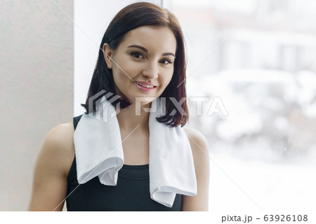 Portrait of smiling young beautiful Caucasian fitness woman in gym, female with towel looking at camera. Fitness, sport, training, people, healthy lifestyle concept. 63926108