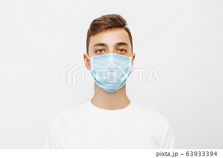 A young man wearing a medical mask to prevent 63933394