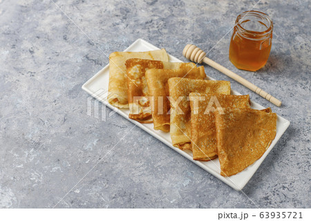 Delicious Breakfast on light background. Orthodox holiday Maslenitsa. Crepes with cumquats and honet,top view 63935721