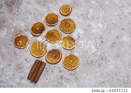 Organic homemade dried orange chips slices,nuts,star anise,cinnamon sticks on light brown background,top view 63935722