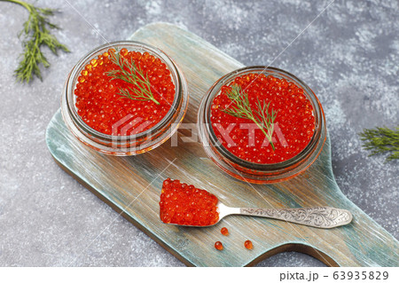 Red caviar in glass bowl and in a spoon,top view Red caviar in glass bowl and in a spoon,top view 63935829