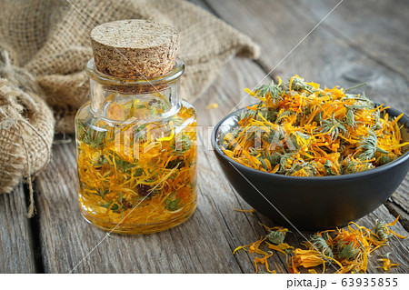 Bottles of calendula infusion, marigold flowers. Bottles of calendula infusion, marigold flowers. 63935855