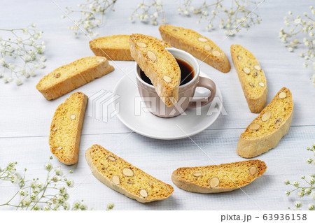 Italian tuscan traditional cookies cantuccini with almonds ,a cup of coffee on light background,top view Italian tuscan traditional cookies cantuccini with almonds ,a cup of coffee on light background,top view 63936158