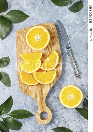 Citrus background with fresh sliced oranges on cutting board on concrete background,top view 63936366