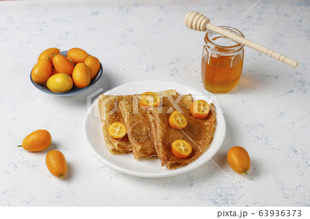 Delicious Breakfast on light background. Orthodox holiday Maslenitsa. Crepes with cumquats and honet,top view 63936373