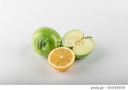 Half lemon with a green apple on white Half lemon with a green apple on white 63936939