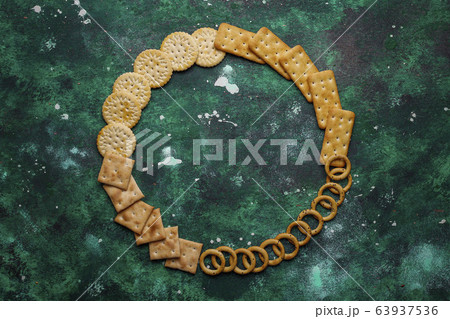 Assortment of salt crackers shot from the top on colorful background with copy space. Salty party snacks mix Assortment of salt crackers shot from the top on colorful background with copy space. Salty party snacks mix 63937536