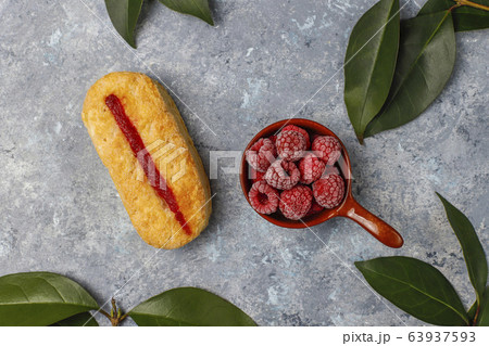 Puff pastry cookies with raspberry jam and frozen raspberries on light background Puff pastry cookies with raspberry jam and frozen raspberries on light background 63937593
