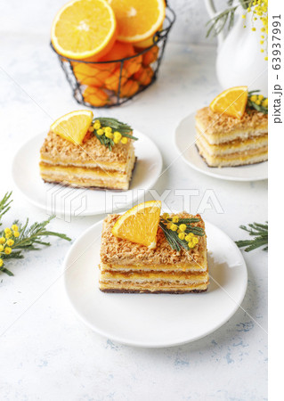 Orange cake decorated with fresh orange slices and mimosa flowers on light background Orange cake decorated with fresh orange slices and mimosa flowers on light background 63937991